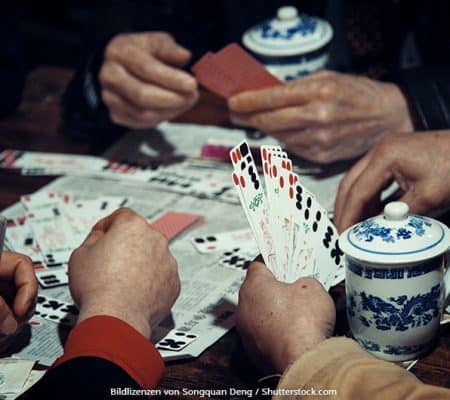 Asiatische Männer spielen Kartenspiel mit Spielkarten