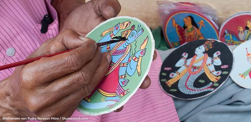 Indischer Mann malt indische runde Spielkarten an