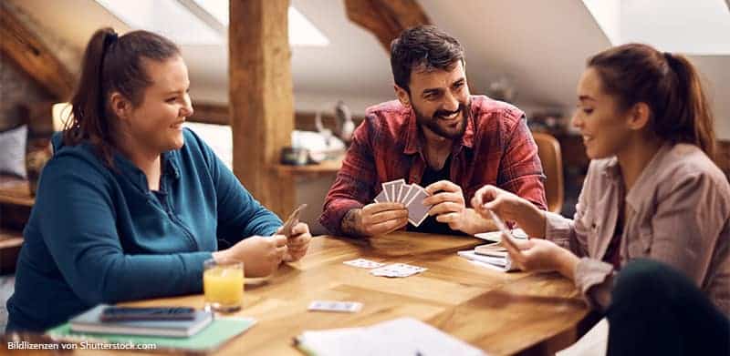 Junge Menschen spielen ind er Mittagspause Karten im COworking-Space