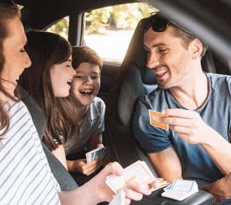 Eine junge Familie spielt Reisespiele im Auto