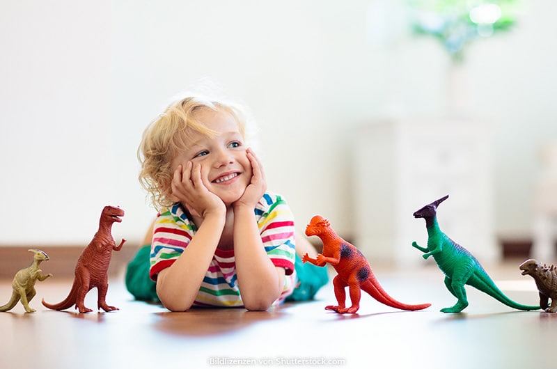 Kleiner Junge spielt mit Dinosauriern