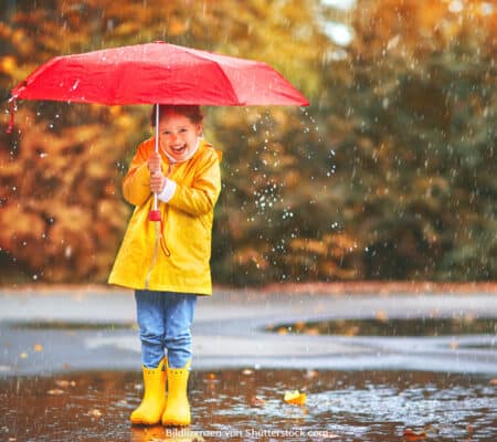 Junges Mädchen steht im Regenwetter lustig