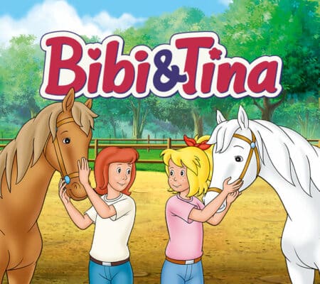 Bibi und Tina mit Sabrina und Amadeus unter Bibi und Tina Logo. Im Hintergrund ist der Pferdestall.