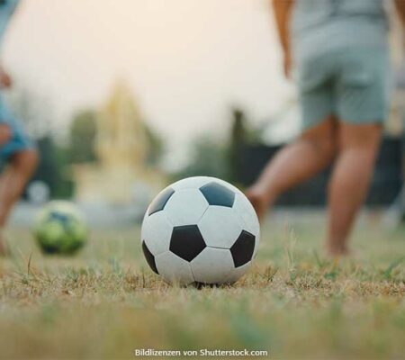 Fußball liegt auf Rasen im Hintergrund spielen Kinder. Kinderfußball, ASS Altenburger