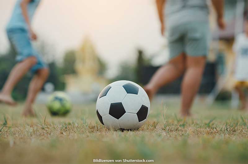 Fußball liegt auf Rasen im Hintergrund spielen Kinder. Kinderfußball, ASS Altenburger