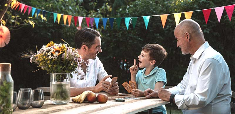 Enkel, Vater und Opa spielen gemeinsam mit Skat-Karten. Familientag, Tag der Familie, ASS Altenburger
