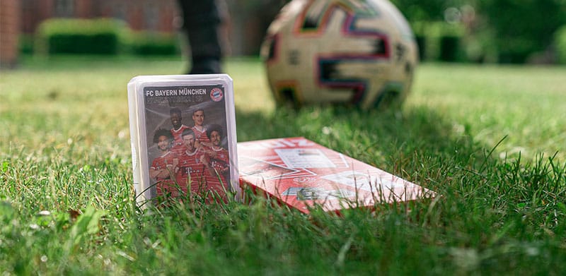 FC Bayern München Quartett und Quiz liegen auf Wiese im Hintergrund ein Ball. Kinderfußball, ASS Altenburger