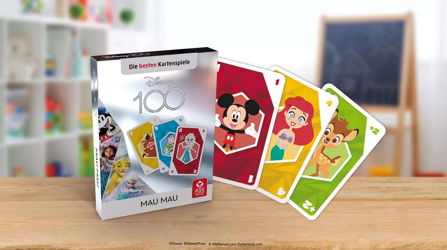 Es ist das ASS Altenburger Disney 100 Mau Mau Kartenspiel mit Schachtel und Karten vor einem bunten Hintergrund zu sehen.