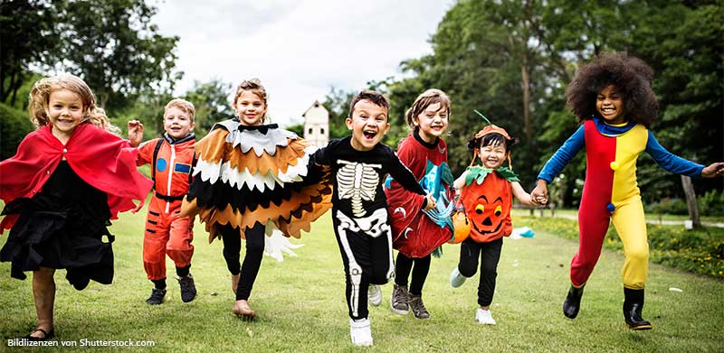 Kinder mit verschiedenen Halloween Kostümen laufen lachend über eine Wiese auf die Kamera zu. Einfache Halloweenkostüme, ASS Altenburger