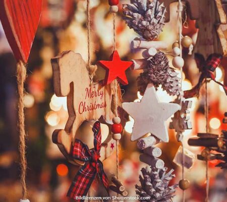 Festliche Dekoration zu Weihnachten mit Holzsternen, Tannenzapfen und einem Schaukelpferd. Weihnachtsmarkt zuhause, ASS Altenburger