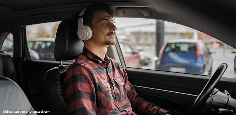 Mann sitzt im Auto, entspannt sich und hört Musik über Kopfhörer. Gute Vorsätze, ASS Altenburger