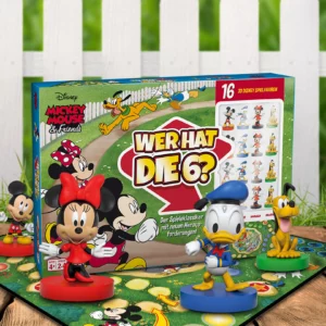 Das Mickey Mouse Wer hat die Sechs Spiel steht auf einem Untergrund aus Holz vor einem weißem Gartenzaun. Das Spielbrett liegt unter der Spielverpackung und es stehen die Figuren von Mickey, Minnie, Donald und Pluto um das Spiel herum.