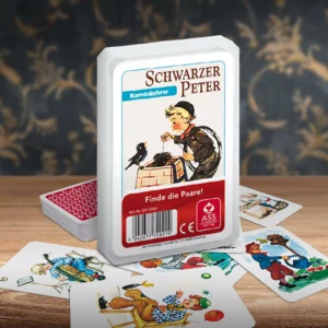 Das Schwarzer Peter Kaminkehrer Kartenspiel steht auf einem Holztisch. Unter dem Spiel liegen einige der dazugehörigen Spielkarten. Im Hintergrund erkennt man unscharf eine mit goldenen Ornamenten verzierte dunkelblaue Wand.