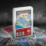 Das Top ASS Jets Trumpfspiel steht auf einem Untergrund aus Asphalt, unter dem Spiel liegen die dazugehörigen Spielkarten. Der Hintergrund ist dunkel und es ist Rauch zu sehen.