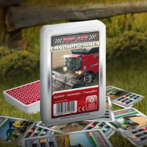 Das Top ASS Landmaschinen Trumpfspiel steht auf einer Wiese, unter dem Spiel liegen einige der dazugehörigen Spielkarten. Im Hintergrund steht ein Zaun der eine anschließende Weide abgrenzt.