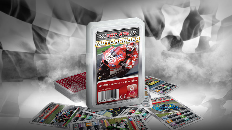 Das Top ASS Motorräder Trumpfspiel steht vor einer wehenden schwarz weiß karierten Rennfahne. Unter dem Spiel liegen die dazugehörenden Spielkarten. Im Hintergrund ist weißer Rauch zu sehen.