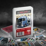 Das Top ASS Trucks Trumpfspiel steht auf einem Untergrund aus Asphalt, unter dem Spiel liegen die dazugehörigen Spielkarten. Der Hintergrund ist dunkel und es ist Rauch zu sehen.