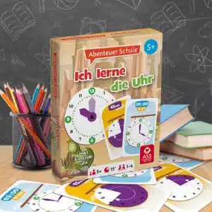 Das Abenteuer Schule Ich lerne die Uhr Spiel steht auf einem Schultisch. Unter dem Tisch liegen einige der dazugehörigen Spielkarten. Neben dem Spiel stehen Stifte und ein Bücherstapel. Im Hintergrund ist unscharf eine Tafel zu erkennen.