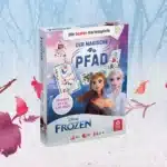 Das Disney Frozen der magische Pfad Spiel steht auf einem verschneitem Untergrund. Im Hintergrund ist ein verschneiter Wald zu erkennen, um das Spiel herum fliegen ein paar bunte Laubblätter im Wind.