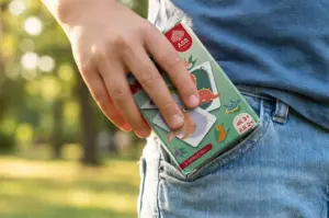 Kartenspiel FSC Tierbabys Memo wird von Hand in Hosentasche einer Jeans gesteckt. Kindertag, ASS Altenburger