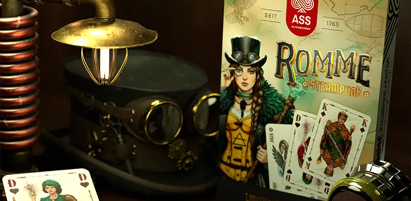 Steampunk Rommé steht auf Tisch neben viktorianischer Lampe und Fliegerbrille. Steampunk Spiele, ASS Altenburger